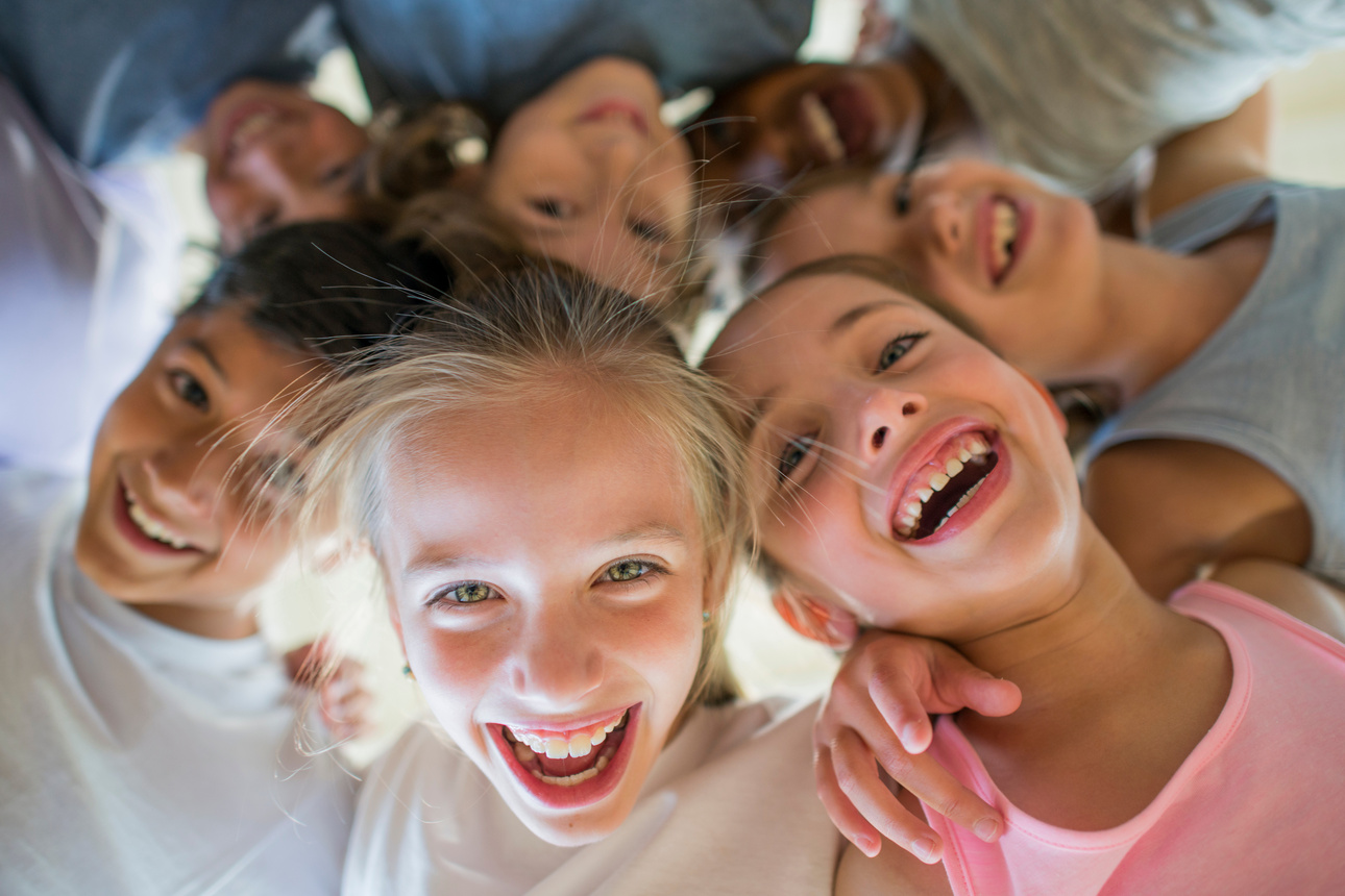 a group of children smiling and looking up at the camera