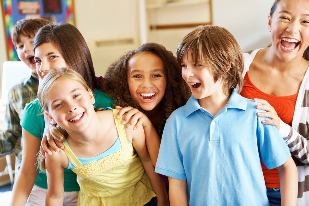 a group of children laughing together in a classroom