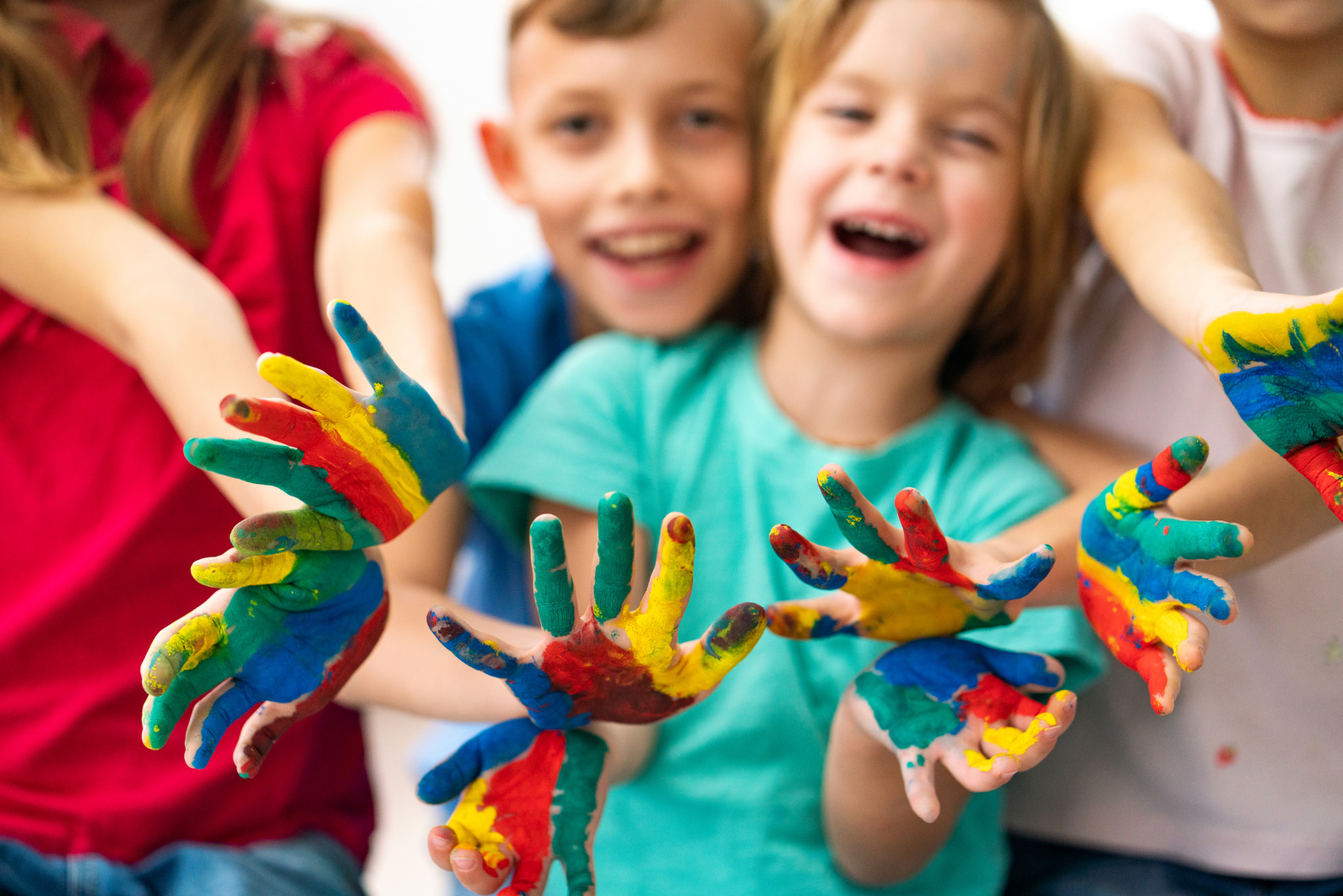 a group of children with their hands painted in different colors