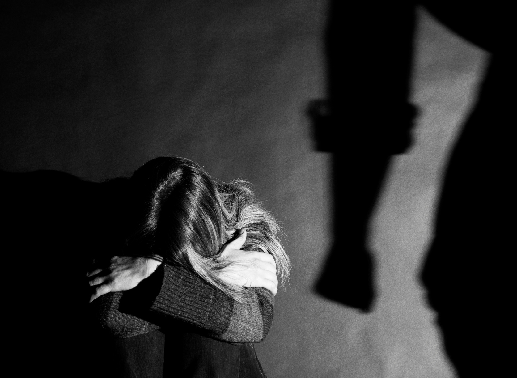 a black and white photo of a woman in a dark room